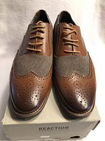 Front view showing brown leather and fabric with brogue perforations on toe caps, and tan laces.