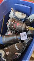 Four pairs of adult inline skates in a blue bin showing different styles and colors.