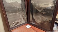 Two framed black and white lake pictures side by side on wooden surface, showing size and frames