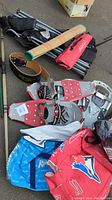 Photo showing lot items including snowshoes, archery bows in cases, foldable chairs, lift belt, and insulated bags