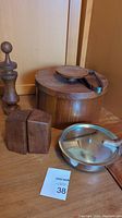 Vintage wooden and metal tableware items including round container, pepper grinder, salt and pepper shakers, and metal pan with lid.