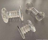 Three crystal utensil rests displayed on table, showing two Waterford pieces and one unmarked piece