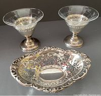 Photo of two sherbet dishes with etched glass bowls and silver bases, and a pierced sterling silver oval dish