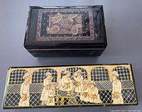 Two decorative boxes shown from top-down: the smaller black lacquered jewelry box with paisley motif and the larger Kashmiri painted box with a traditional scene.