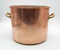 Front and side view of the copper pot showing its size and brass handles on both sides.
