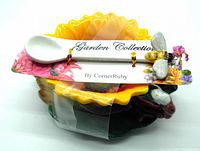 Top view of the packaged set showing yellow sunflower tea cup, leaf saucer and white bee spoon with Corner Ruby Garden Collection tag