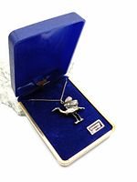 Pewter heron pendant displayed inside a blue velvet-lined box.