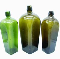 Front view showing three antique gin case bottles in olive and green glass with applied lips and square shoulders