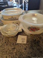 Assorted casserole dishes arranged on countertop showing various sizes and styles with some lids attached