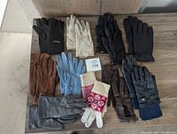 Top view showing all ten pairs of assorted gloves in various materials and colors arranged on a flat surface.