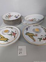 Full set displayed on table showing the 8 dinner plates stacked, the pie plate with lid, casserole with lid, and 2 oval serving dishes. Fruit and vegetable pattern visible with gold trim details.