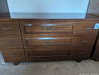 Front view of full wooden dresser with six drawers and brass handles, some scratches visible on top surface.