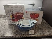 Punch bowl set with boxes and Pyrex nesting bowls on countertop