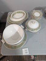 Assorted china pieces displayed on table: covered casserole with lid, side plates, platters and bowls