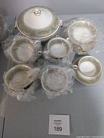 Overhead view of all pieces: covered server at top, teacups and saucers grouped below