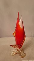 Front side photo of the vintage Murano glass shark vase showing the pointed snout, orange/red color gradient, fin detail, and decorative swirled base.