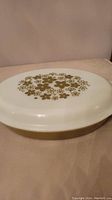 Top view of the Pyrex casserole dish with lid on, showing floral green spring blossom design on white lid.