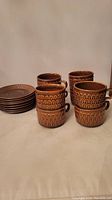 Set of 8 stacked cups and 8 stacked saucers showing the pattern and condition.