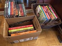 Three boxes of assorted cookbooks on floor with titles visible including Ina Garten, Williams-Sonoma, Barefoot Contessa.