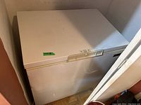 Front view of white Kenmore chest freezer showing overall condition and dimensions sticker.