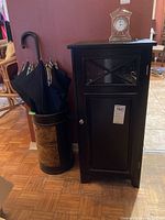 Cupboard and umbrella stand with umbrellas located indoors on hardwood and tile floors, showing full items