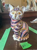 Front view of Royal Crown Derby cat figurine showing detailed red, blue, and gold Imari pattern and gold-painted eyes