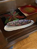 Five serving plates on a shelf showing styles, colors, and designs.