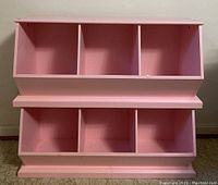 Front view showing entire pink toy storage unit with two sections and six open compartments.