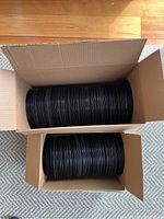 Two boxes filled with stacked 45 RPM vinyl records, showing quantity and storage method.