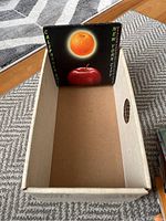 Box containing a California-themed 45 RPM record with artwork of an orange and apple on a black background