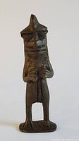 Front view of bronze figurine showing facial features and posture