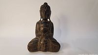 Full front view of the carved wooden Buddha statue showing meditative pose and details.