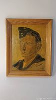 Framed oil painting showing a portrait of a young man in military uniform, signed and dated 1943
