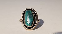 Front view showing turquoise stone and silver bezel setting with decorative elements.