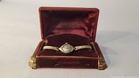 Front view of vintage women's Bulova wristwatch with expansion metal band and silver dial in velvet presentation box