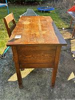 Side view of wooden kids desk showing wood grain and leg detail