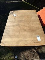 Top view showing surface scratches and wear on light brown wooden table.