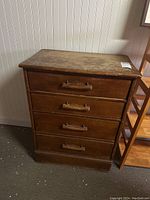 Front view of the wooden dresser showing all four drawers and wooden handles.
