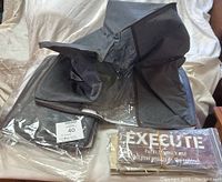 Three large collapsible cloth boxes stacked with two wooden signs partially visible underneath.