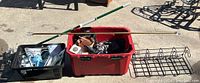 Wide shot of all items including mop, curtain rods, black basket, red storage bin, hanging bracket organizer, and assorted items inside bins.