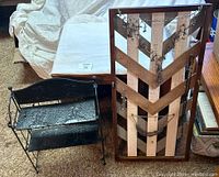 Front view of black metal shelving unit beside wooden framed jewelry holder with jewelry