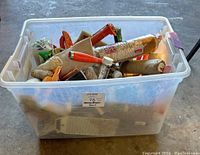 Clear Rubbermaid bin filled with assorted painting and caulking tools including rollers and brushes.