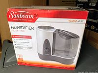Photo of the Sunbeam humidifier in its original box, showing brand, model, and key features.