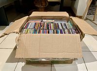 Overhead photo showing the entire packed cardboard box filled with numerous CD jewel cases, revealing the volume and general presentation.