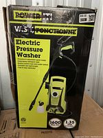 Photo of the unopened box showing an electric pressure washer with 1600 PSI maximum pressure and 1.35 GPM flow rate, including features like soap-spray detergent tank and quick-connect hose.