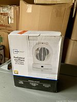Photo of boxed Mainstays electric oscillating space heater showing front of box with product image and French/English labeling.