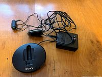 Photo showing the Sony round base station, power adapter, and wired handset with cables.