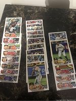Photo showing multiple Topps MLB rookie cards laid out on a table, including players from Reds, Giants, Padres, and Angels teams.