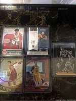 Six NBA rookie cards displayed, featuring Simons, Oturu, Fultz, and Davis with various card issuers and special prizm effects.