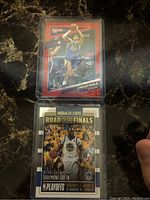 Front view of Jordan Poole and Draymond Green NBA trading cards in protective cases, showcasing player images and numbering.